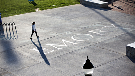 woman walking on sidewalk that says EMORY